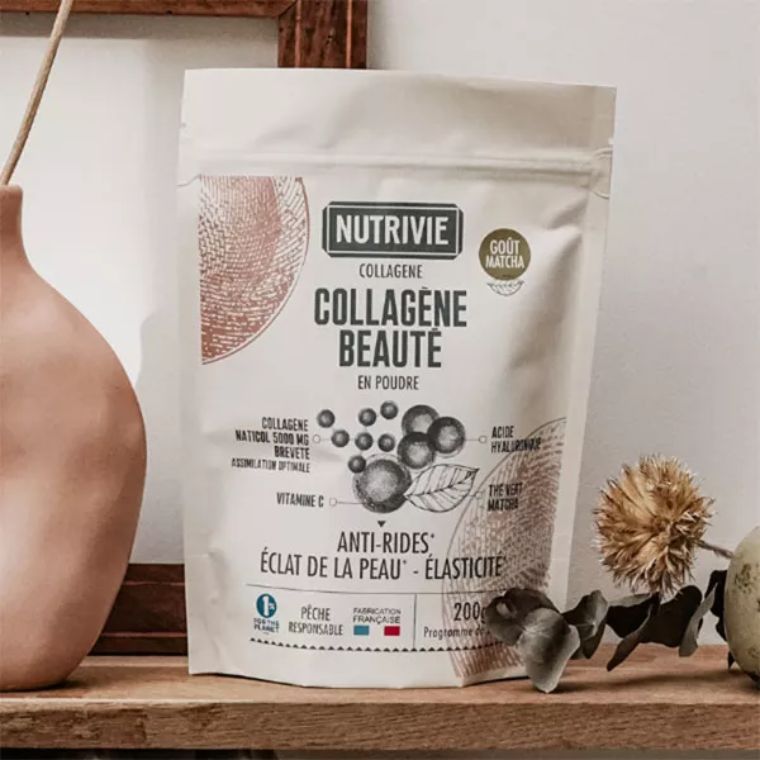 Sachet blanc de poudre de collagène beauté goût matcha sur étagère en bois avec décoration florale
