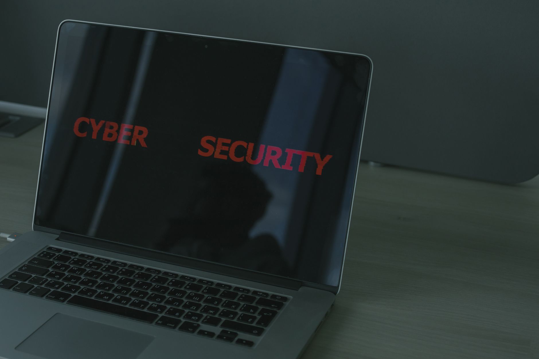 Laptop displaying the text 'CYBER SECURITY' in red letters on a dark screen
