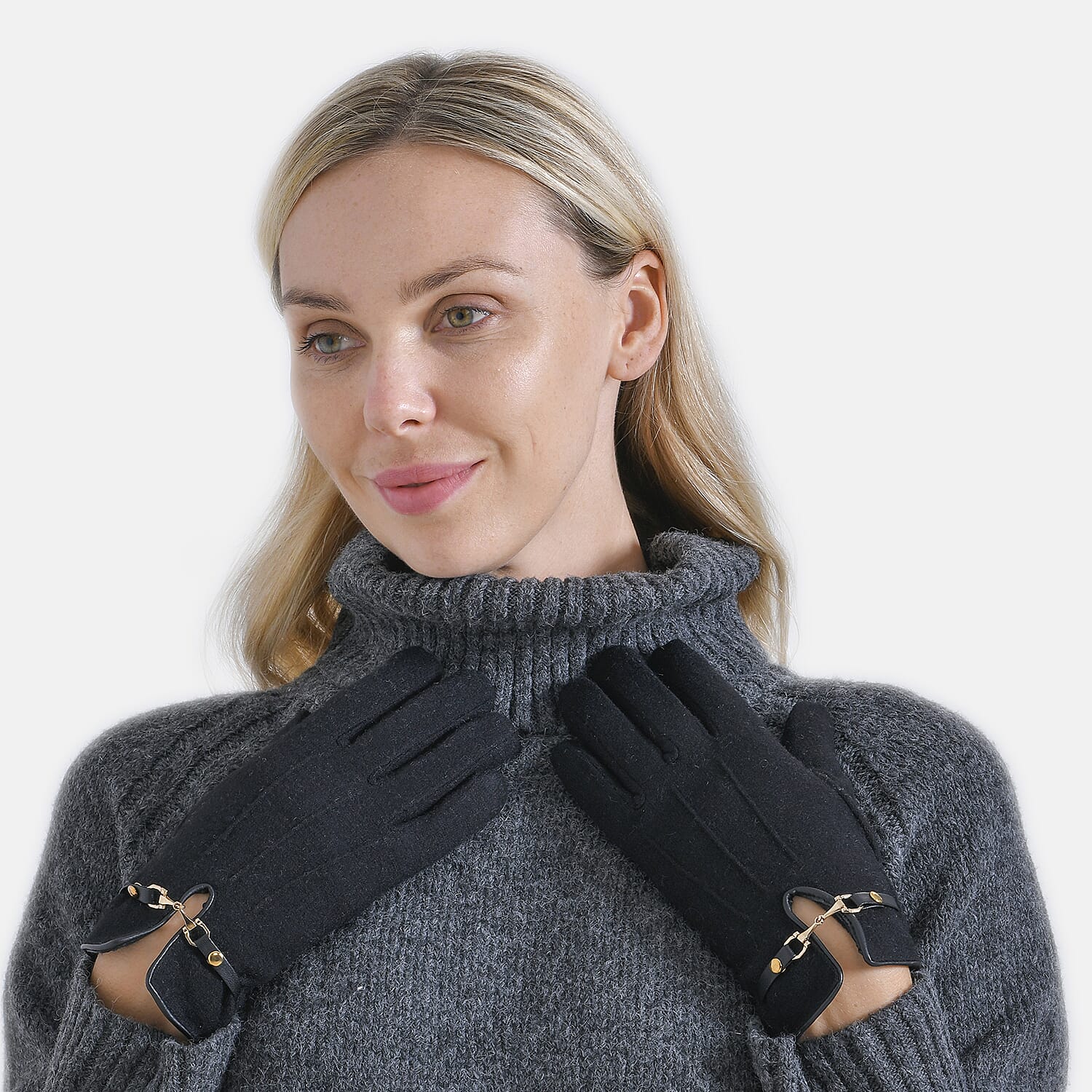 Woman wearing gray turtleneck sweater and black gloves with decorative buckle trim, looking to the side