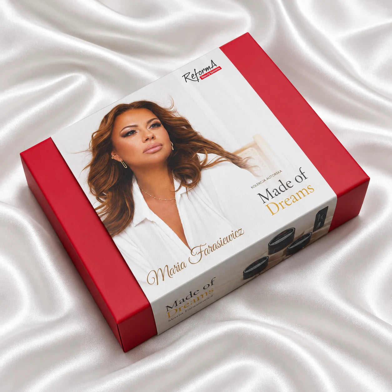 Otwarte pudełko kolekcji Made of Dreams ReformA Beauty Systems leżące na białym satynie z wizerunkiem dziewczyny w białej koszuli