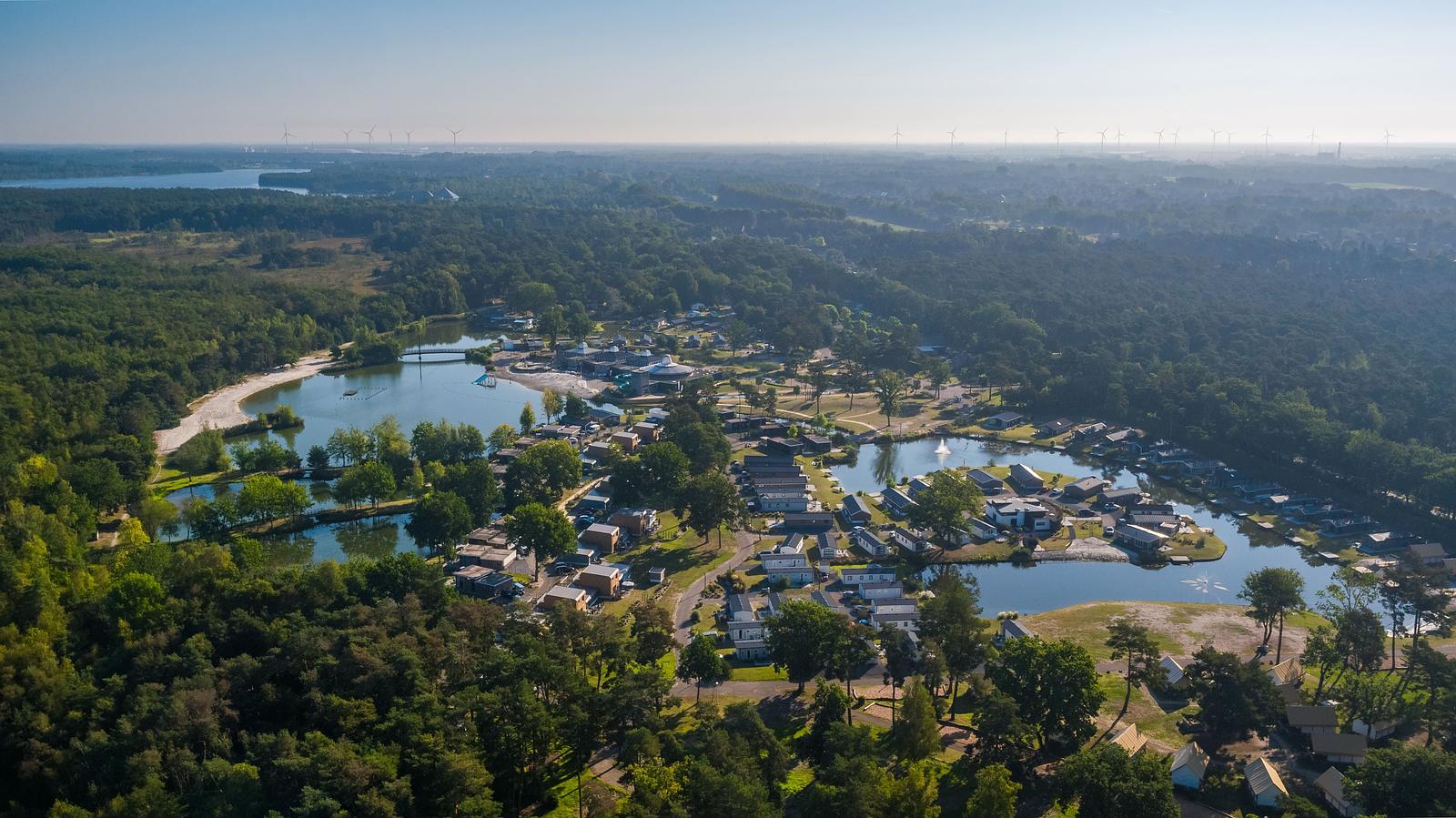 Luftaufnahme von Ferienpark mit Häusern um mehrere Seen in grüner Waldlandschaft