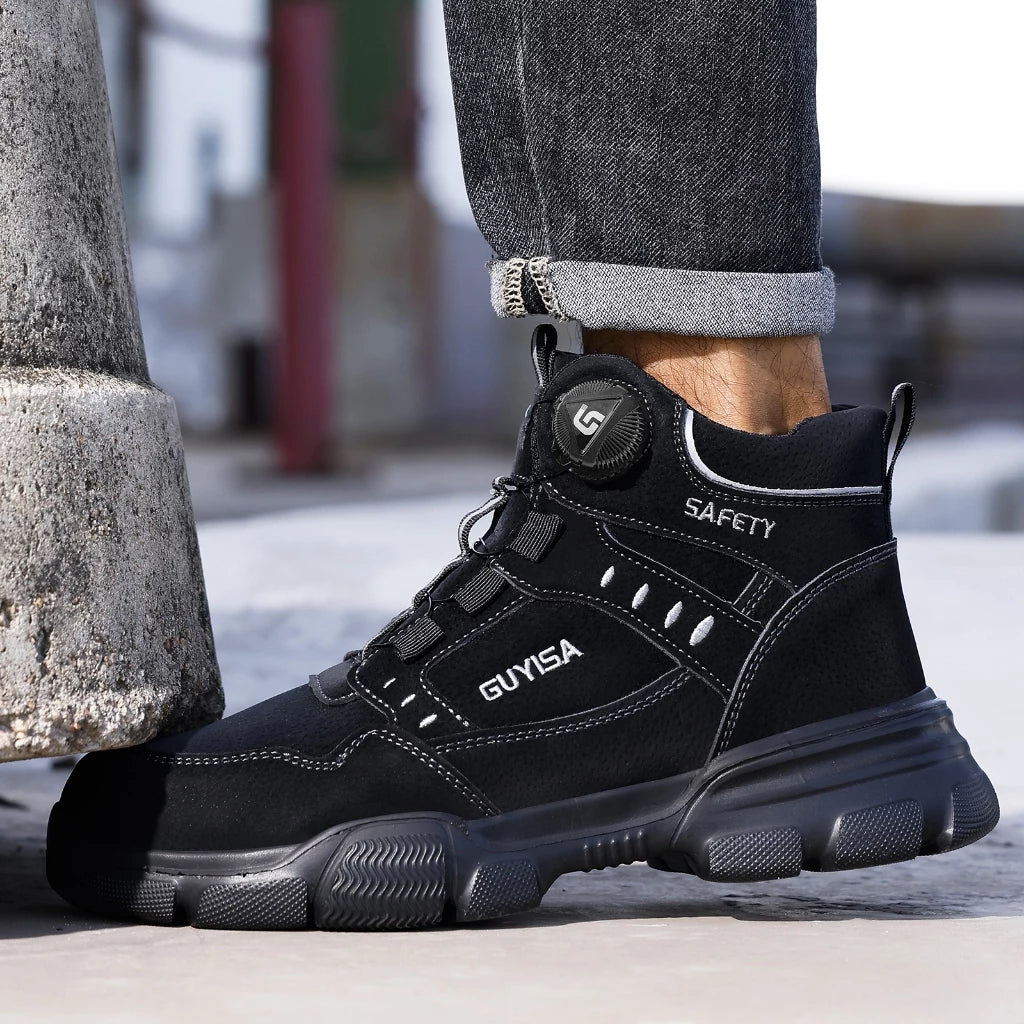 Person wearing black safety boots with chunky grip sole, standing against concrete pillar outdoors